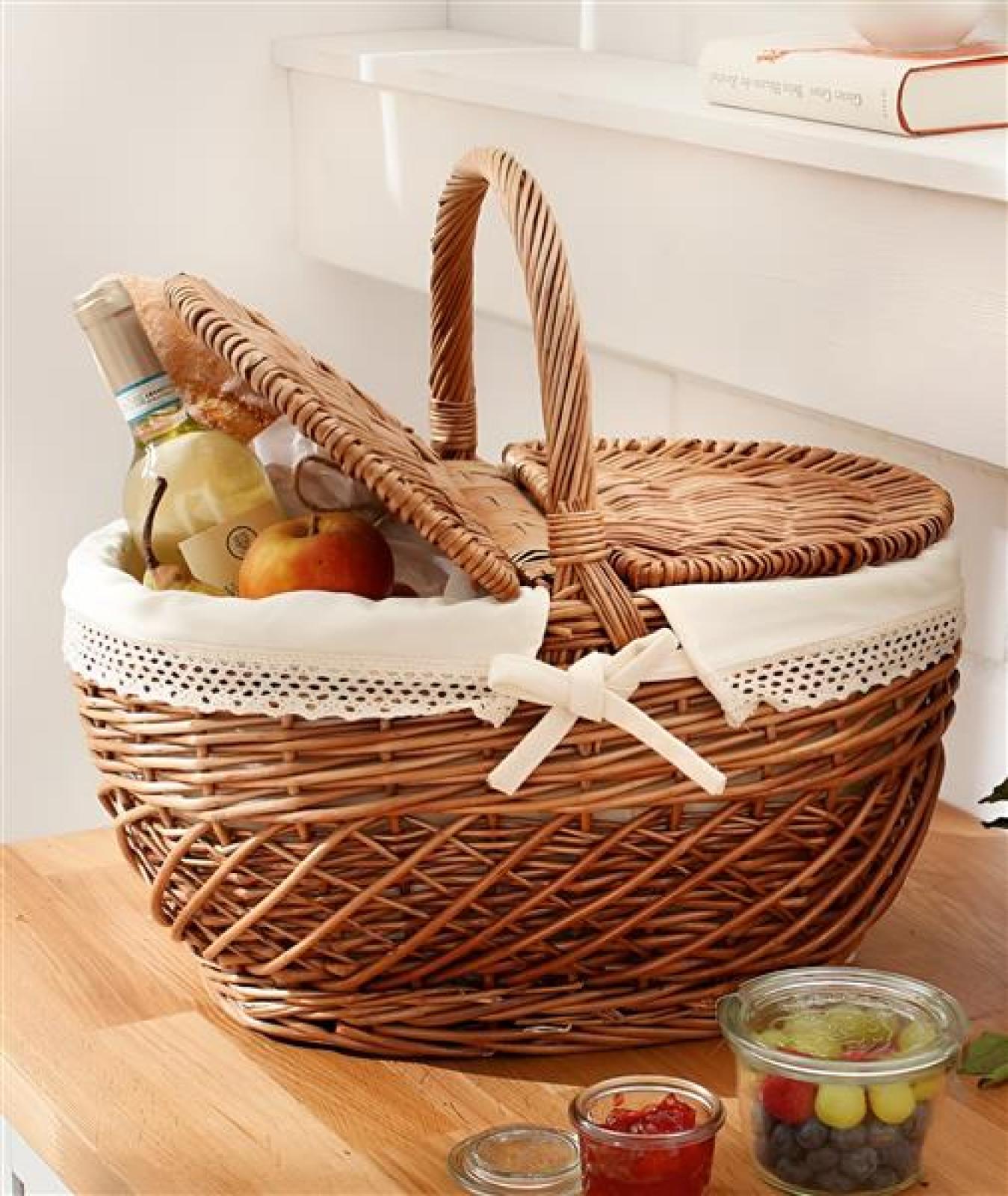 Picknickkorb aus Weide mit Klappdeckel und Textileinsatz mit Häkelborte, gefüllt mit Brot, Wein und Obst